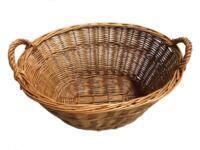 Rummelig æblekurv i pileflet fyldt med æbler, velegnet til opbevaring af frugt i køkken eller bryggers.